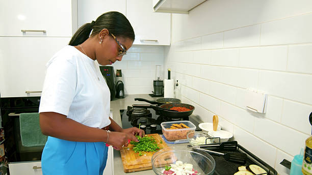 istock Woman carefully chopping fresh parsley in a modern kitchen 2224488512