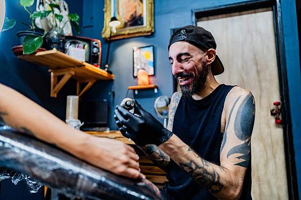 Tattoo artist creating detailed art on a customer's hand in a modern and professional tattoo studio