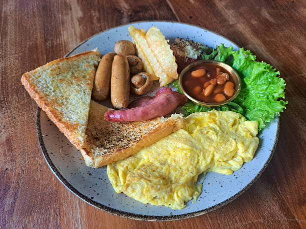 Restaurant Breakfast With Choised Egg, Beef Sausage, Potato Wedges, Baked Bean, Lettuce, Mushroom Champignon, Smoked Beef And Toast Bread. Food Menu.