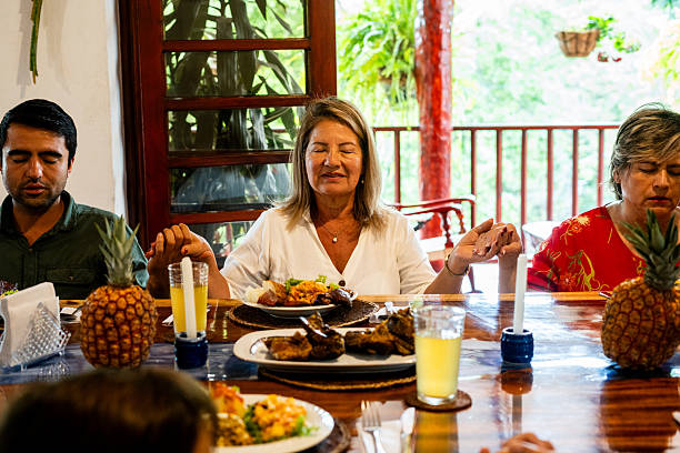 istock Family gathered at home, praying before lunch 2224491330