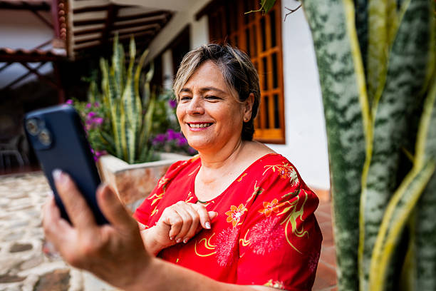 istock Senior woman using mobile phone at house backyard 2224491478