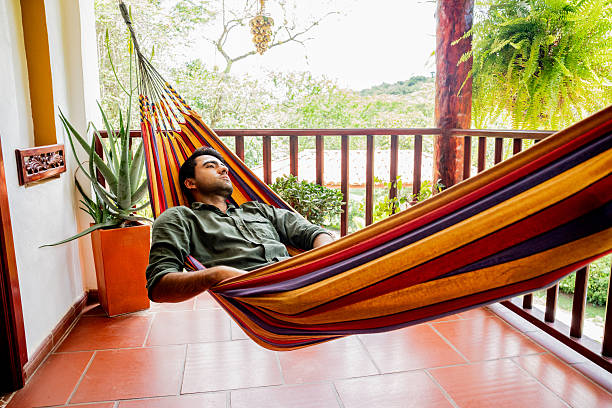 Young man relaxing in a hammock on a peaceful day at home