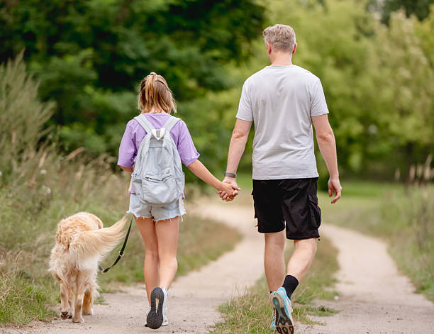 istock Dad Walking With Daughter And Dog In Summer 2224496804
