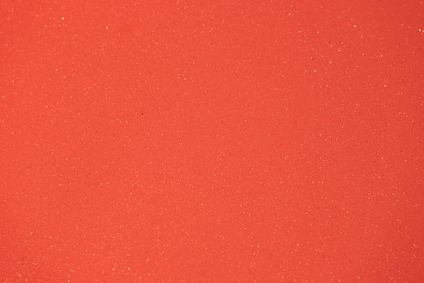 Bright orange textured surface with shimmering particles creating a vibrant aesthetic appeal for design or art projects