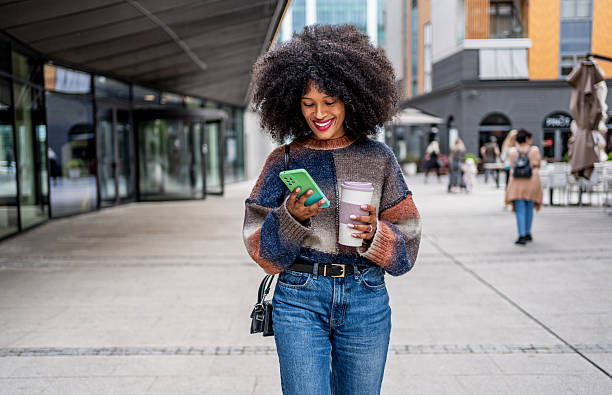 istock Stylish woman enjoying coffee and using smartphone in urban setting 2224497430