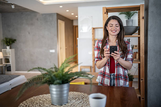 istock Young woman using smartphone and smiling at home 2224498732