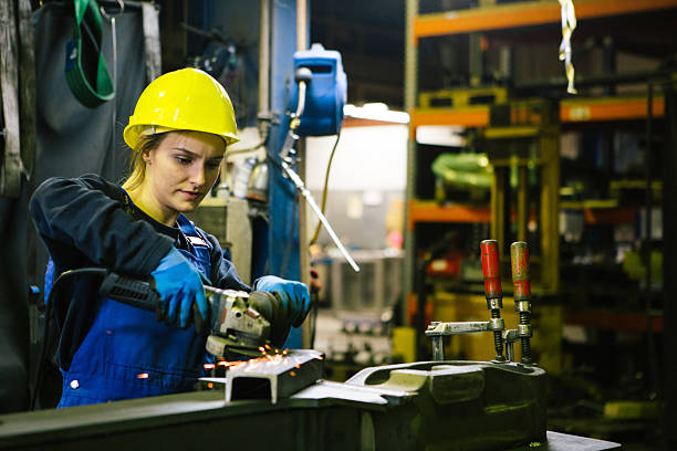 istock Young female trainee welds steel with grinder in workshop 2224499915