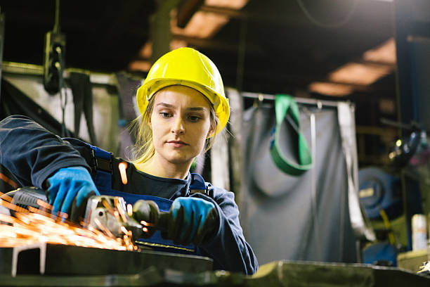 istock Young female trainee welds steel with grinder in workshop 2224499916