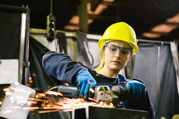 istock Young female trainee welds steel with grinder in workshop 2224499925