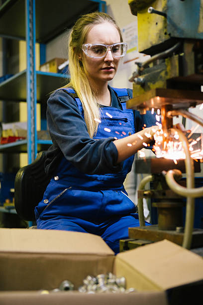 istock Young female trainee welds steel with grinder in workshop 2224500014