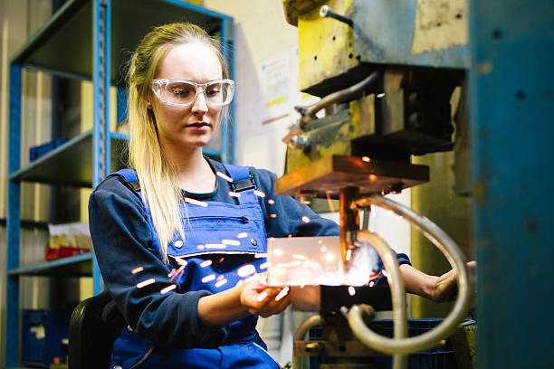 Close up of senior electrician wearing safety glasses while connecting wires in distribution board.