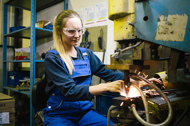 istock Young female trainee welds steel with grinder in workshop 2224500049