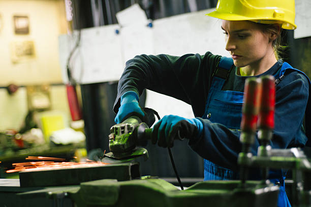 istock Young female trainee welds steel with grinder in workshop 2224500126