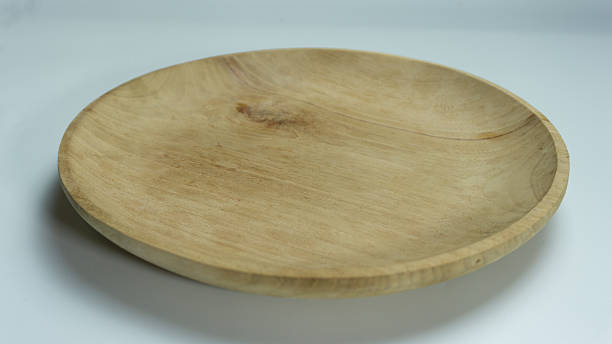 istock Single wooden plate on white background, clean minimalist top-down composition with natural material, ideal for packaging or dining-related mockups 2224500779