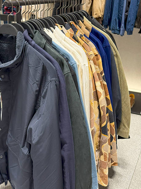 istock Neutral Toned Clothing Rack with Jackets, Sweaters, and Shirts on Hangers 2224503100