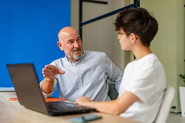 istock Senior executive engages in collaborative discussion with female colleagues in a modern office setting 2224507547