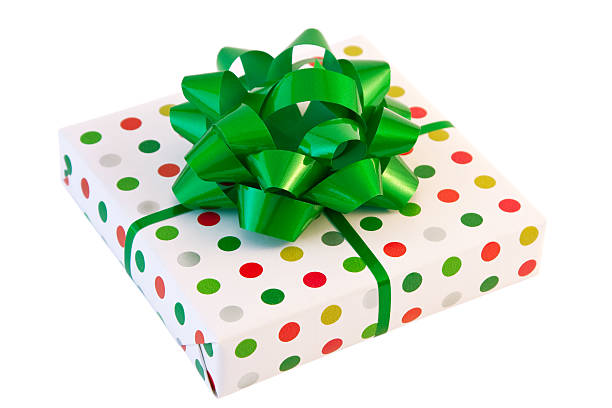 Small square box wrapped in green, red, silver, gold and white polka dot wrapping paper  with green bow and ribbon.