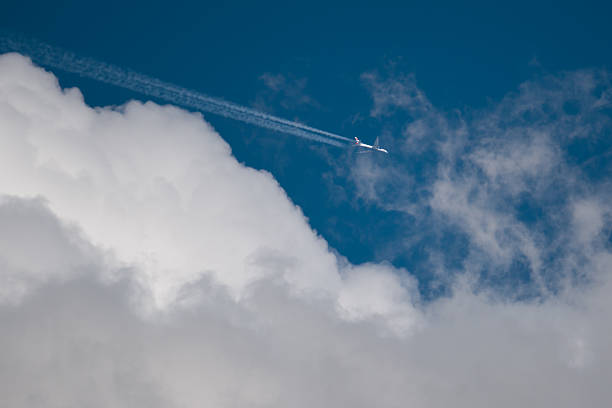 istock Airplane flies among bizarre clouds in blue sky 2224511621