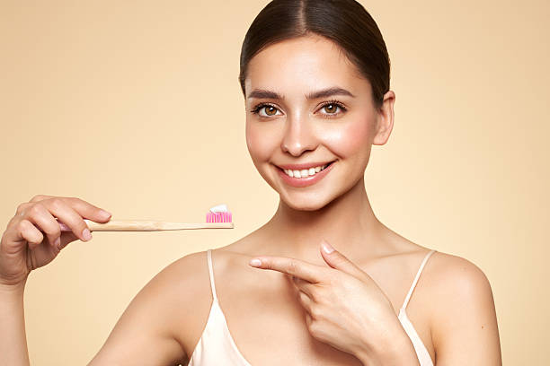 istock Beautiful young woman brushing her teeth 2224511962