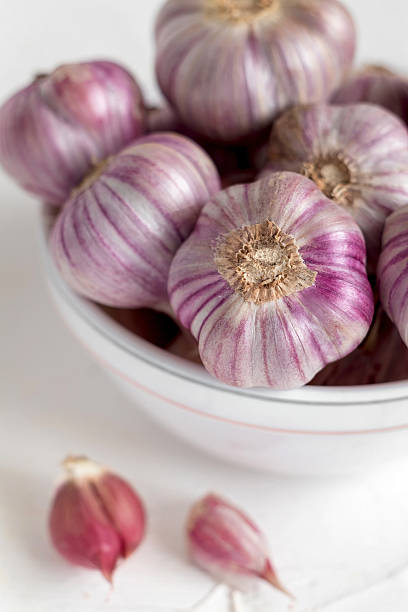 istock Fresh violet garlic close up in a white bowl. 2224512320
