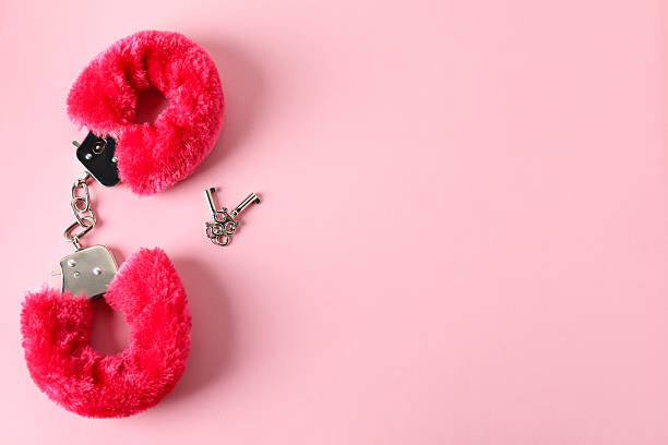 istock Fluffy handcuffs and keys on pink background, flat lay. Space for text 2224513918