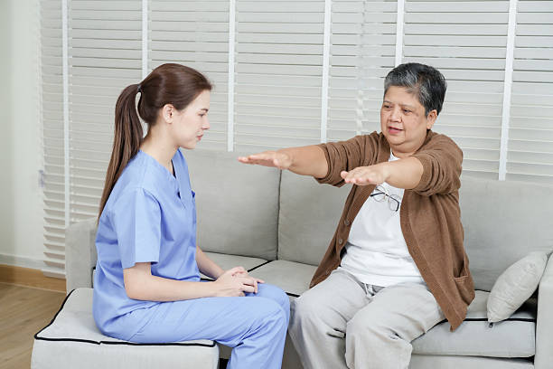 istock Senior asian woman extending arms forward performing shoulder movement exercise while female therapist monitors session in rehabilitation setting focused on improvement 2224514222