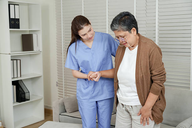 istock Physiotherapist holding senior asian woman hand gently while supporting controlled walking practice to improve strength and movement in elderly rehabilitation session 2224514254