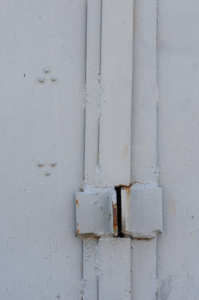 istock Close up of a white door with a rusty bolt and padlock 2224516932