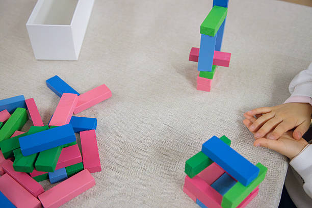 istock A young child plays indoors during the day, focusing intently while building a structure with colorful wooden blocks, developing fine motor skills, creativity, and early cognitive abilities. 2224521885