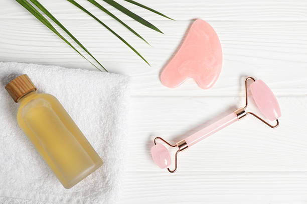 istock Face roller, gua sha tool and cosmetic product on white wooden background, flat lay 2224522138