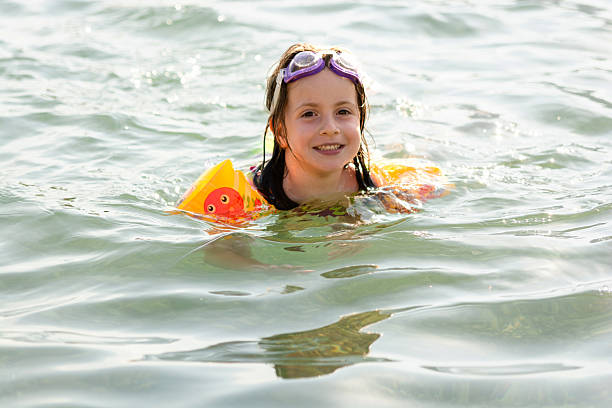 Carefree little child girl swimming in sea