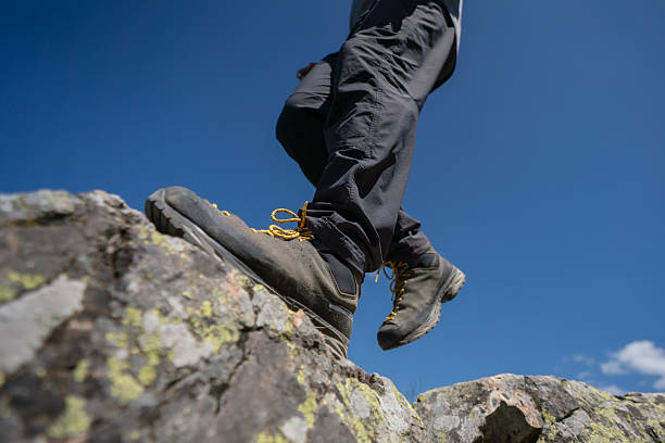 istock Close-Up of Hiker's Boot on Rocky Trail Under Clear Blue Sky 2224525063