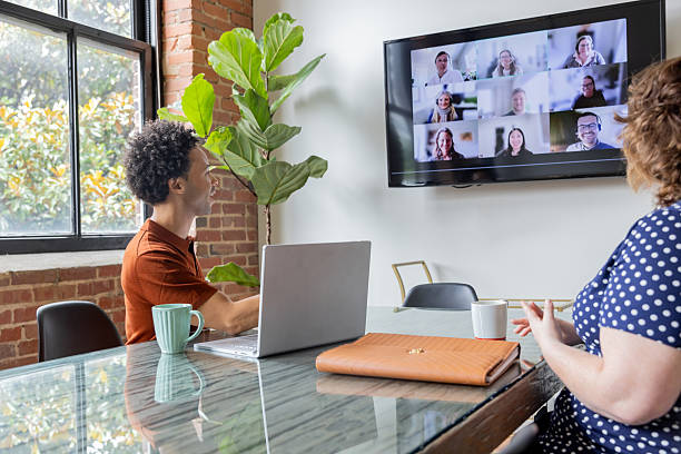 istock Diverse young colleagues meet with virtual team on screen in modern board room 2224528549