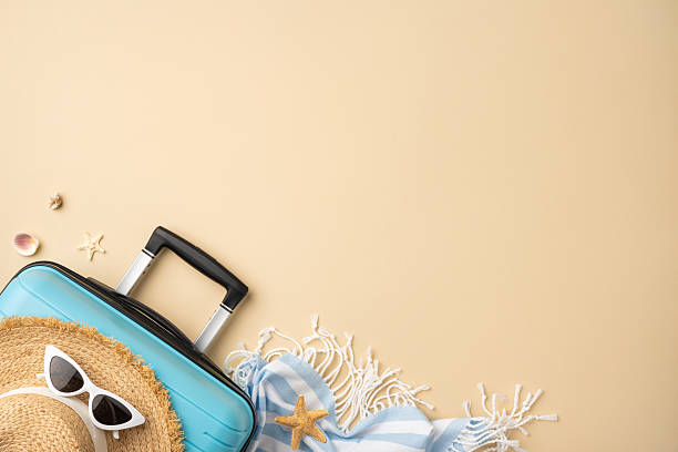 istock Summer travel items on beige background featuring suitcase, straw hat, sunglasses, and shells showcasing a vacation theme and relaxed atmosphere 2224532023