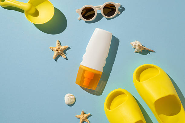 Flat lay composition featuring summer essentials such as sunscreen, sandals, and beach-themed decorations