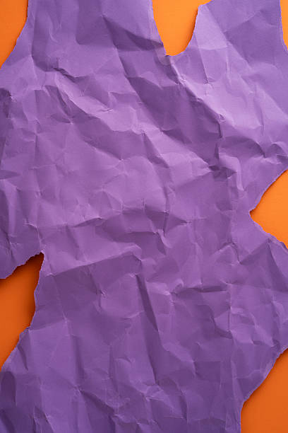 Crumpled purple vertical paper revealing a vivid orange contrast emphasizing bold textures and colors