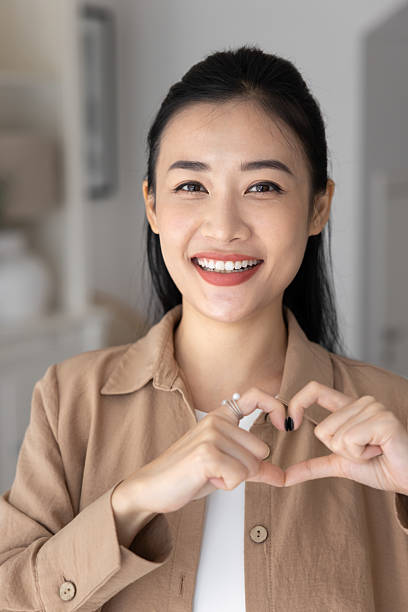 istock Female showing to camera heart-shaped gesture making with her fingers 2224532112