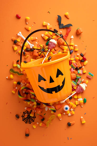 istock Halloween-themed vertical setup featuring a pumpkin bucket alongside festive candies and seasonal objects 2224532119