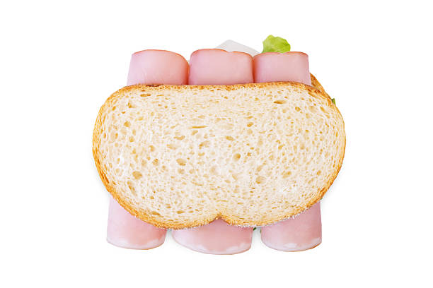 A sandwich made for lunch on a yellow cutting board at home in the kitchen.