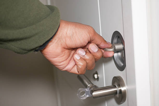 istock Hand unlocking a door at home in the evening 2224533515