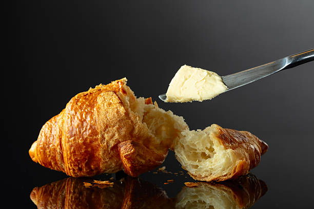istock Fresh baked croissant with butter on a black background. 2224535475