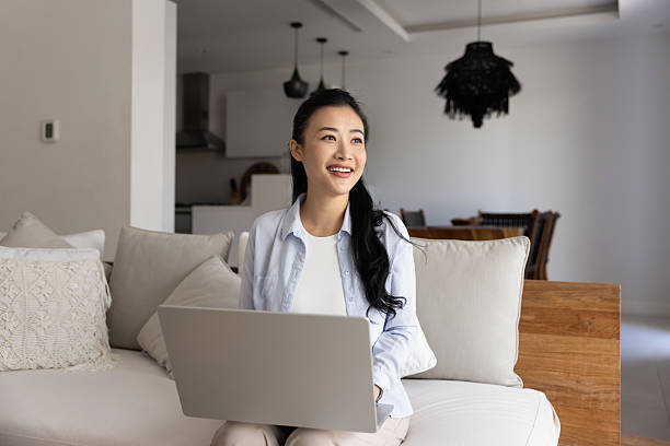 istock Smiling Asian woman using laptop working remotely 2224535540