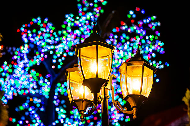 Christmas lantern with warm light surrounded by blue LED fairy lights at night festive market scene