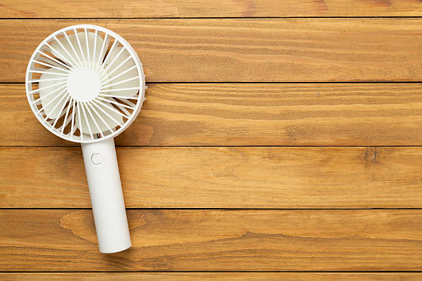 istock Mini electric fan on wooden background, top view 2224538162