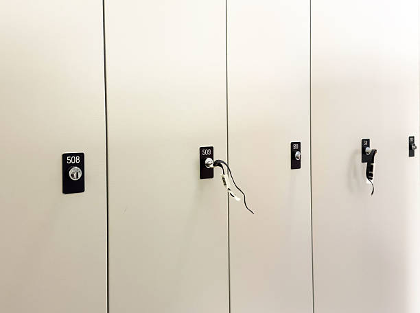 istock Sleek white locker doors with numbered locks and hanging wires 2224541842