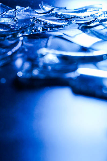 Broken Glass Shards on Dark Surface with Cold Blue Lighting