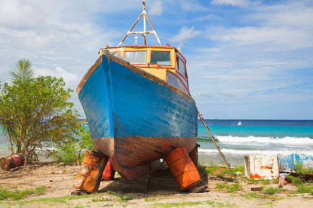 Barbados, Bridgetwon,  old broken fishing boat on land