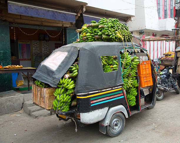 India, New Delhi, bananas  stuffed into tok tok  taxi car.