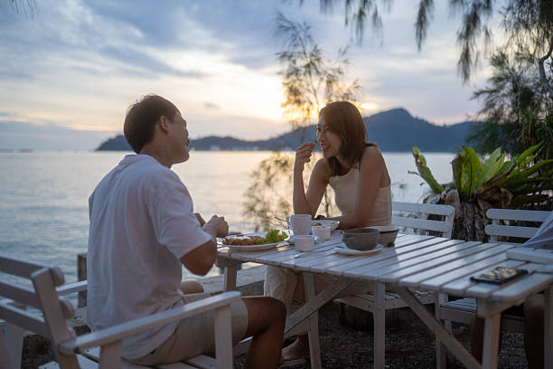 istock 2 Asian Chinese couple dining on beach at sunset 2224550188