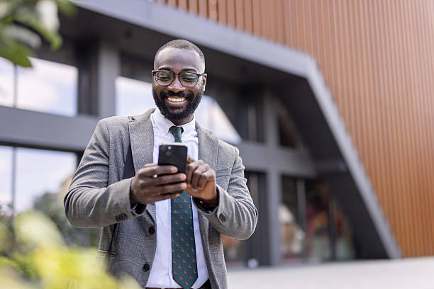 istock Smiling professional reviewing messages on his smartphone 2224552901